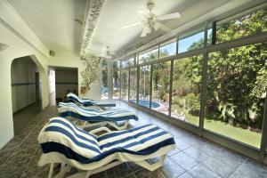 eine Reihe von Liegestühlen in einem Zimmer mit Fenstern in der Unterkunft Villa Bejar Tequesquitengo in Tequesquitengo