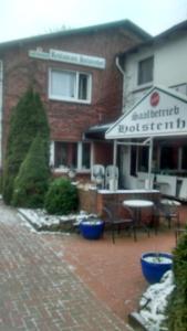 ein Gebäude mit einer Terrasse mit einem Tisch und Stühlen in der Unterkunft Holstenhof"garni" in Schmalfeld