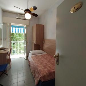ミラノ・マリッティマにあるHotel Capriのベッドルーム1室(ベッド1台、シーリングファン付)