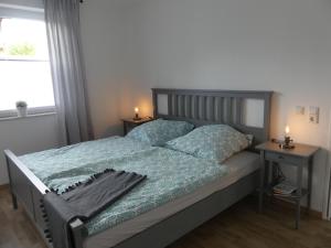 1 dormitorio con 1 cama con 2 mesitas de noche y una ventana en Ferienwohnung Lüdenstein, en Bad Rothenfelde