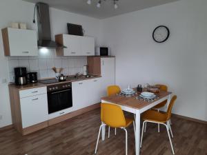 a kitchen with a wooden table and yellow chairs at Ferienwohnung Lüdenstein in Bad Rothenfelde