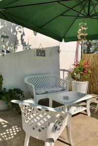 ガラトーネにあるLa casa del Soleの緑の傘下のテーブルと椅子