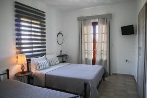 1 Schlafzimmer mit 2 Betten und einem Fenster in der Unterkunft Studios Filio Sonia in Vourvourou