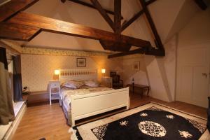 Un dormitorio con una cama grande en una habitación con techos de madera. en B&B Snellenstein, en Neerijnen