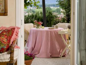 a pink table with flowers on it on a balcony at Casa Marinelli in Farra di Soligo