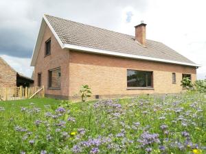 a house with a field of flowers in front of it at De Calonne in Veurne