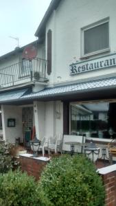 um restaurante com mesas e cadeiras em frente a um edifício em Holstenhof"garni" em Schmalfeld