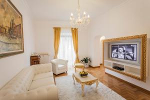 ein Wohnzimmer mit einem weißen Sofa und einem TV in der Unterkunft Suite Sarandrea in Rom