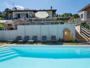 a swimming pool with chairs and a house at Nice apartment with terrace just steps from the beach in Ledro
