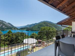 een balkon met uitzicht op een meer en de bergen bij Nice apartment with terrace just steps from the beach in Ledro