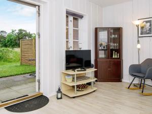 a living room with a television and a table with a chair at 4 person holiday home in R m in Rømø Kirkeby