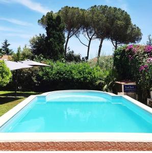 una grande piscina blu in un cortile di Etna Shelter Holiday House a Mascalucia