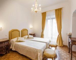 1 dormitorio con 2 camas y lámpara de araña en Suite Sarandrea, en Roma