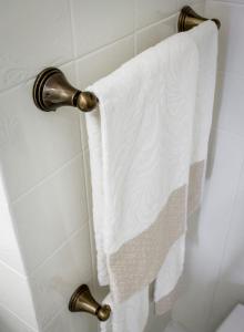 a white towel hanging on a shower curtain at Suite Sarandrea in Rome +30 photos