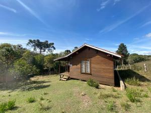 una piccola cabina in legno in un campo alberato di Pousada Aguaraguazu a Tibagi