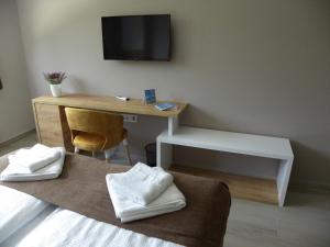 een hotelkamer met een bureau en een televisie bij Kate Central Apartments in Ohrid