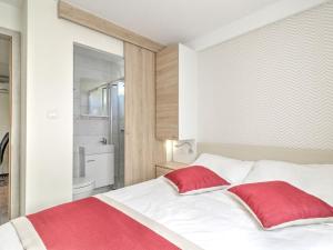 sypialnia z białym łóżkiem z 2 czerwonymi poduszkami w obiekcie Mobile Home in Banjole near Beach & Pool w mieście Banjole