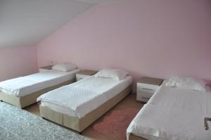two beds in a room with white walls and wooden floors at Balcı Apartment in Eceabat