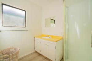 a bathroom with a sink and a mirror at Coastal Hill Retreat - Tairua Holiday Home in Tairua +17 photos