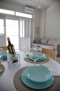a table with a bottle of wine and glasses on it at Family apartments 1 in Lékhaion