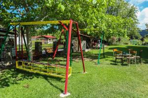 a park with a swing set in the grass at Studios Filio Sonia 2 in Vourvourou