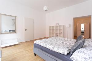 - une chambre blanche avec un lit et un miroir dans l'établissement Charming Flat & Balcony near CentralStation Apt 5, à Vienne