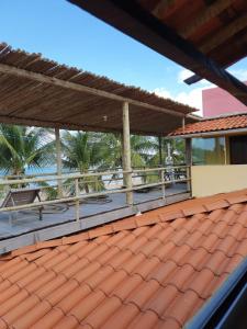 雅帕拉廷加的住宿－Pousada Mama Pereira，一座带甲板和棕榈树的建筑的屋顶