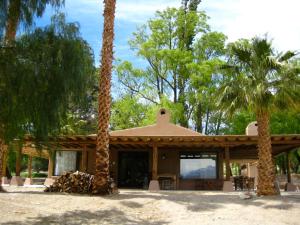 a building with palm trees in front of it at LOVELY MOUNTAIN HOUSE in a finca in Barreal