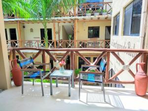 un patio con 2 sillas y una mesa en el balcón en La Constanza de Rulo en Holbox Island