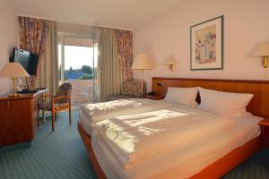 a hotel room with a bed and a desk at Hotel-Restaurant Esbach Hof in Kitzingen