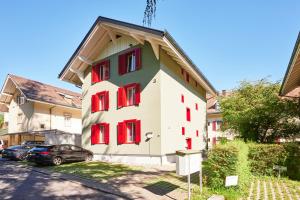 un bâtiment avec des fenêtres rouges sur une rue dans l'établissement da Maurizio Suites, à Berne