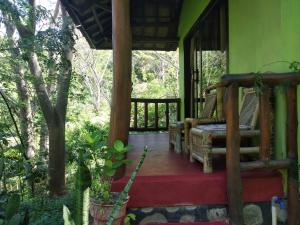 a porch of a house with a porch swing at Kuta Mountain Bungalows in Kuta Lombok