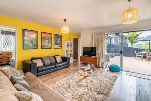 a living room with a couch and a tv at La Petite Maison - Akaroa Holiday Home in Akaroa