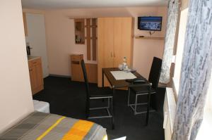 HilchenbachにあるFerien-/Monteurwohnung Olbrichのテーブルとベッド付きの小さな部屋