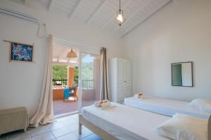 sypialnia z 2 łóżkami i balkonem w obiekcie Odyssey villas w Kassiopi