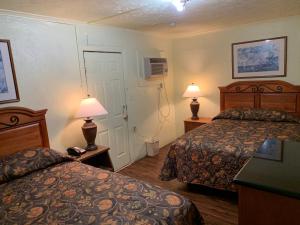 a hotel room with two beds and two lamps at Economy inn in Bay City