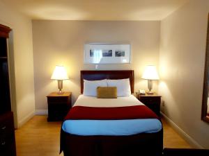 ein Hotelzimmer mit einem Bett mit zwei Lampen in der Unterkunft Seely's Motel in Shediac
