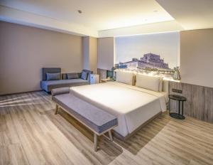 um quarto com uma grande cama branca e um sofá em Atour Hotel Yuyang West Road em Yulin