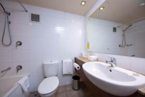 a bathroom with a sink and a toilet and a mirror at Holiday Inn Auckland Airport by IHG in Auckland