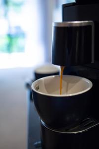 a cup of coffee is being poured into a bowl at Holiday Inn Auckland Airport, an IHG Hotel in Auckland