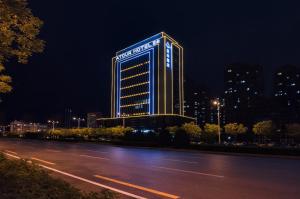 un edificio iluminado al lado de una calle en Atour Hotel Yuyang West Road en Yulin