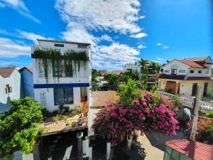 a view of a building with flowers on a balcony at Sam Sam Homestay in Hoi An