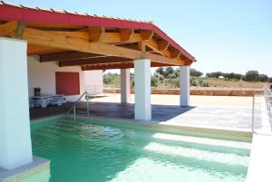 a swimming pool with a pavilion and water at Casa da Urra in Urra