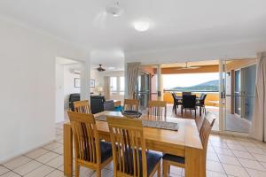 a dining room table and chairs in a room at Martinique Whitsunday Resort in Airlie Beach