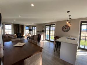 a kitchen and living room with a table and a counter at Pedalfish Cottages - Galaxy Views in Twizel