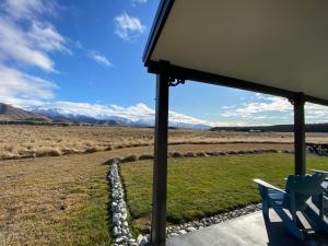 a porch with a chair and a view of the mountains at Pedalfish Cottages - Galaxy Views in Twizel