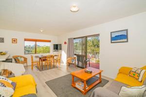 a living room with a couch and a table at Coastal Hill Retreat - Tairua Holiday Home in Tairua
