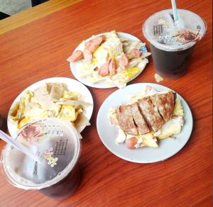 a table with three plates of food and a drink at 別野山莊民宿 in Baisha
