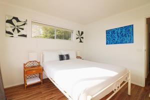 Un dormitorio blanco con una cama grande y una ventana en Beachcomber - Pet Friendly, en Merimbula