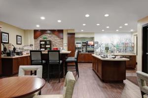 a restaurant with a bar with chairs and tables at Staybridge Suites Washington D.C. - Greenbelt, an IHG Hotel in Lanham